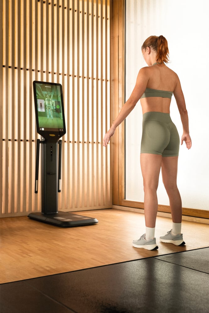 Kuntoilija seisoo Technogym Checkup -kehonanalyysilaitteen edessä.