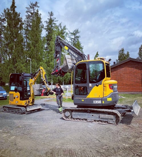 Pienempi ja suurempi kaivinkone vastakkain työmaalla.